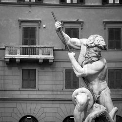 Statue of woman in front of building