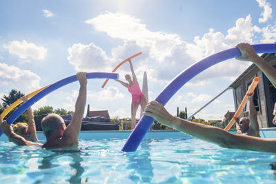 Group of seniors with trainer doing water gymnastics in pool