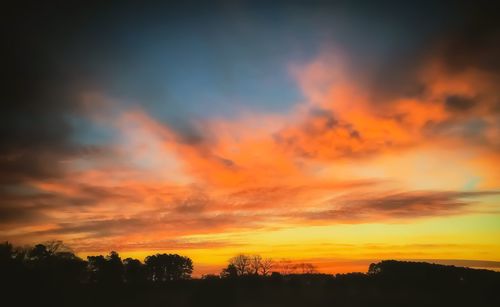 Scenic view of silhouette landscape against orange sky
