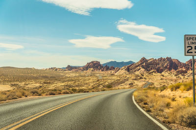 Empty road by landscape against sky