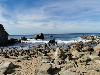 Rocks on beach against sky