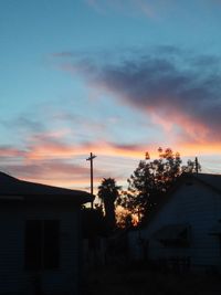 Low angle view of house against sky at sunset