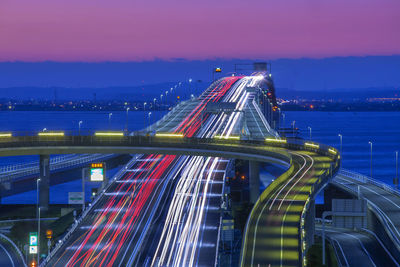 Illuminated bridge in city against sky at night