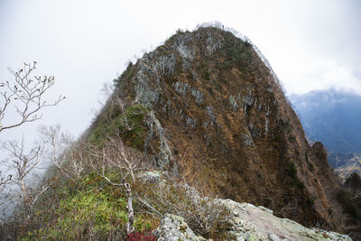 Low angle view of frost on rock against sky