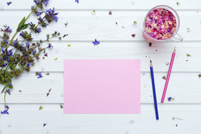 Directly above shot of paper with pencils and drink on table