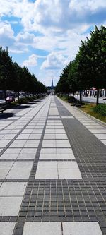 Surface level of footpath by road against sky