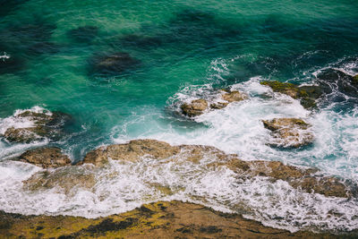 High angle view of rocks at sea shore