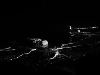 Aerial view of illuminated sea against sky at night