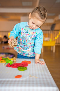 Portrait of cute girl playing with toy on table