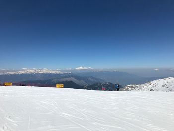 Scenic view of snow mountains against blue sky