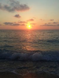 Scenic view of sea against dramatic sky during sunset