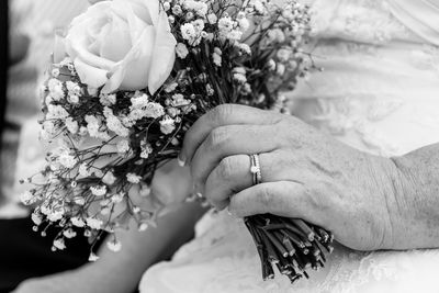 Midsection of woman holding bouquet of flowering plant