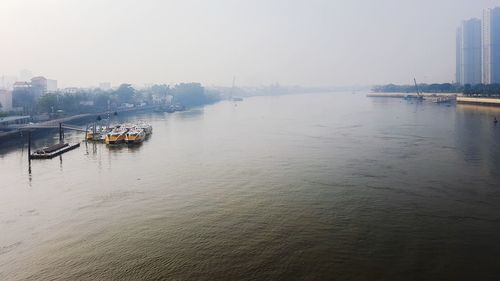 Boats in river against buildings in city