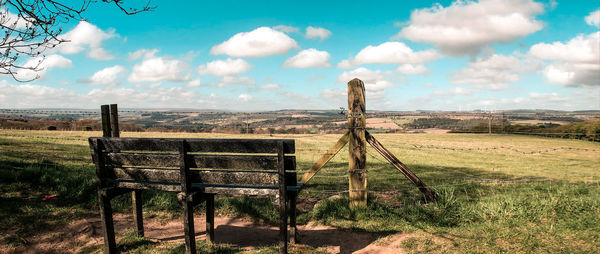 Wooden fence on field against sky