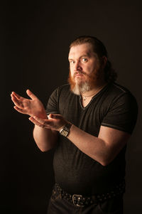 Midsection of man standing against black background