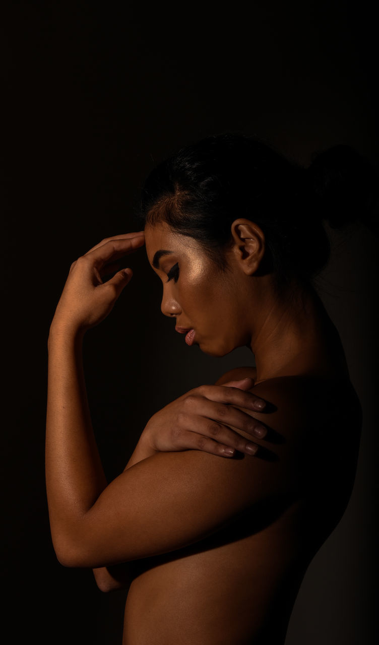 studio shot, young adult, one person, young women, black background, real people, standing, side view, beautiful woman, lifestyles, indoors, close-up