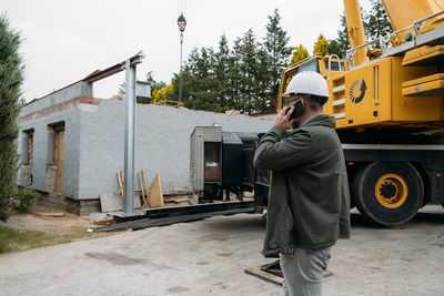 Foreman talking by phone on construction site. architect discussing project using smart phone