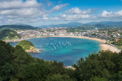 High angle view of townscape by sea against sky