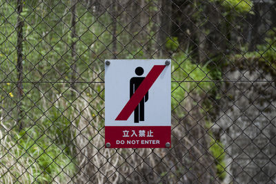 Do not enter sign on chainlink fence at forest