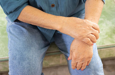 Midsection of man holding hands standing outdoors