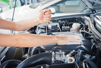 Hand cleaning car engine with a rag,worker
