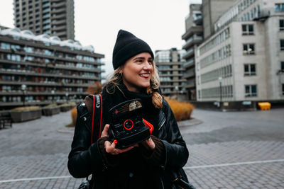 Portrait of beautiful woman standing on street in city