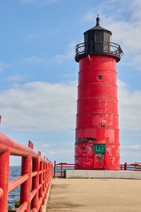 Lighthouse by sea against sky