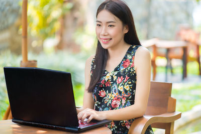 Businesswoman using laptop while sitting at outdoor cafe