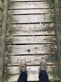 Low section of man standing on boardwalk