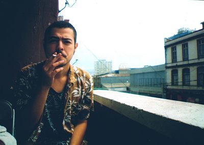 Portrait of man in city against sky