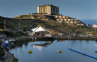 Lake and buildings against sky at bali wake park on sunny day