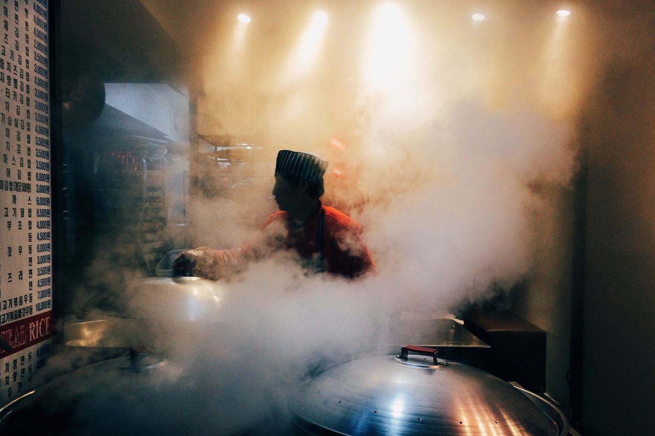 indoors, illuminated, night, lifestyles, men, leisure activity, glass - material, blurred motion, full length, window, smoke - physical structure, motion, light - natural phenomenon, transparent, reflection, unrecognizable person, smoke, person