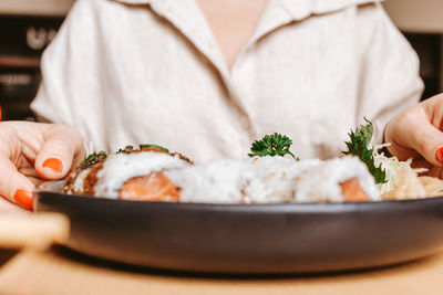 Midsection of woman having food on table