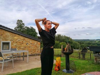 Full length of teenage girl standing on field against sky