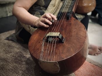 Midsection of man playing guitar