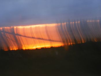 Close-up of silhouette field against sky at sunset