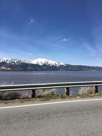 Road by mountain against sky during winter
