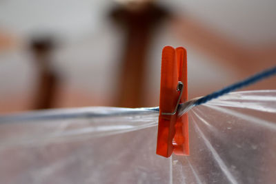 Close-up of orange clothespin on plastic