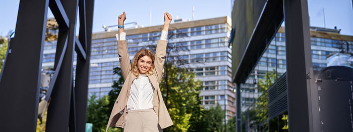 Low angle view of woman standing against sky