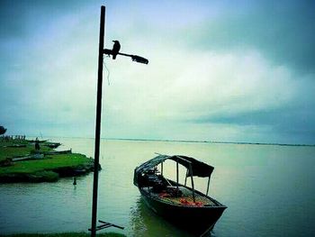 Street light against cloudy sky