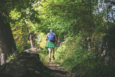 Man walking in the mountain forest. male with backpack do hike in the nature. guy goes trekking