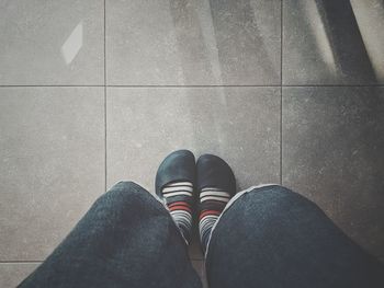 Low section of person on tiled floor