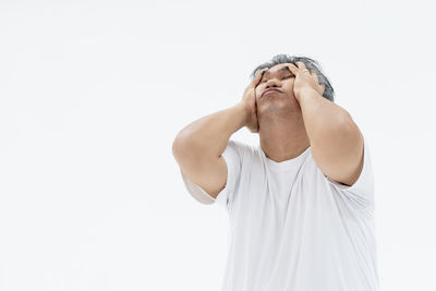 Young man standing against white background