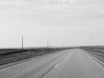 Empty road on field against sky