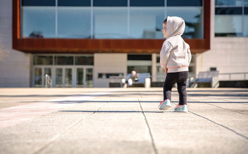 Rear view of boy walking in city