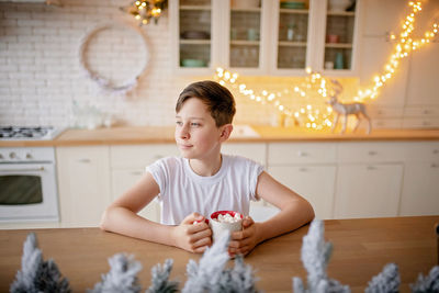 Boy drinking on table at home