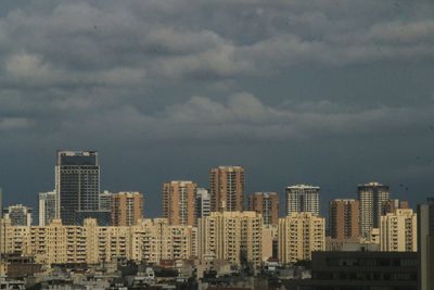 Buildings in city against cloudy sky, gurugram haryana