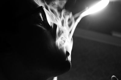 Close-up portrait of man against illuminated light