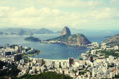 Panoramic view of city by sea against sky