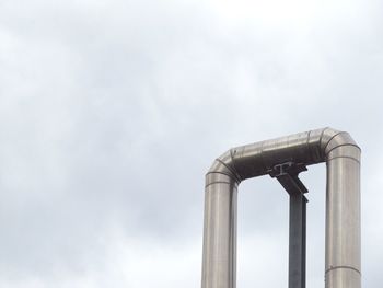 Low angle view of smoke stacks against sky